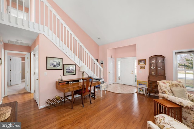 entrance foyer with stairway, baseboards, and wood-type flooring