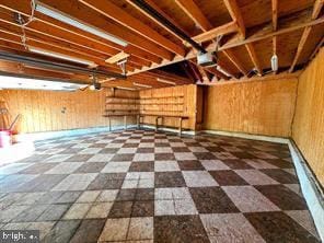 basement featuring tile patterned floors and wooden walls