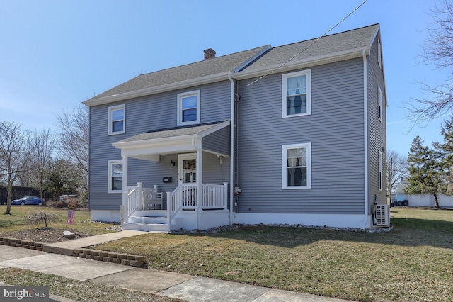 traditional-style house featuring a porch, a front yard, and a chimney