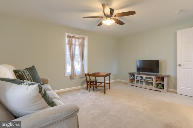 living area featuring baseboards, carpet floors, and a ceiling fan