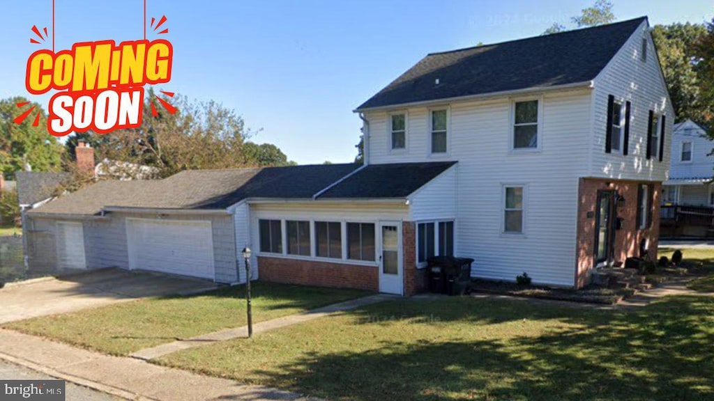 view of front facade featuring a front yard, an attached garage, and driveway