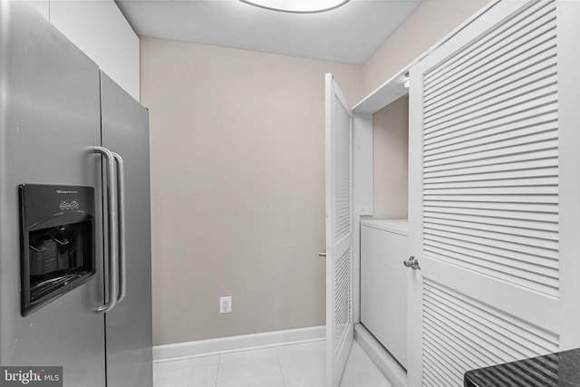 laundry area featuring light tile patterned floors, laundry area, washer / clothes dryer, and baseboards