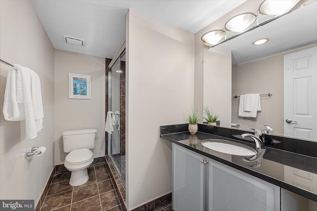 full bathroom with vanity, a shower stall, toilet, and visible vents