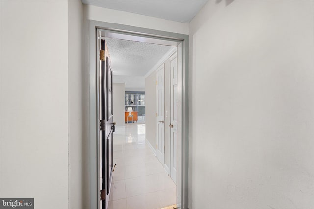 hall with light tile patterned floors and a textured ceiling