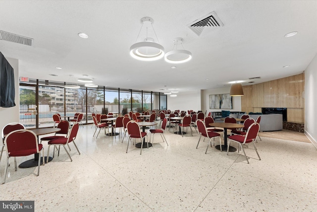 dining area with a wealth of natural light, visible vents, and wood walls