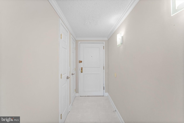 hallway with light tile patterned floors, baseboards, a textured ceiling, and crown molding