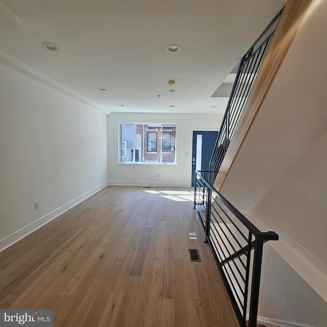 interior space featuring visible vents, recessed lighting, wood-type flooring, baseboards, and stairs