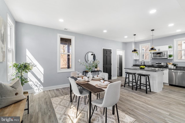 dining area featuring recessed lighting, light wood-type flooring, and baseboards