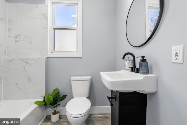 full bath featuring a sink, toilet, baseboards, and wood finished floors