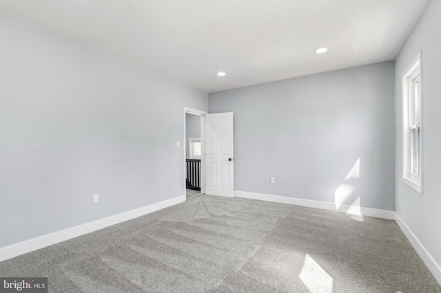 carpeted empty room featuring recessed lighting and baseboards