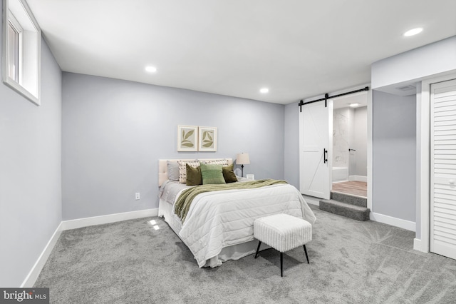 carpeted bedroom featuring a barn door, recessed lighting, and baseboards