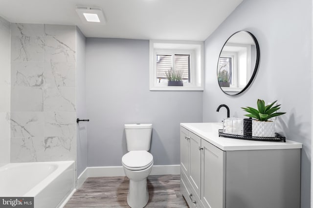 bathroom with baseboards, toilet, wood finished floors, and vanity