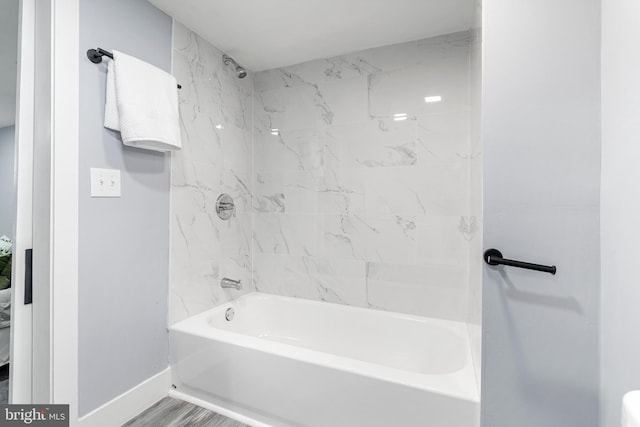 full bath featuring baseboards and washtub / shower combination