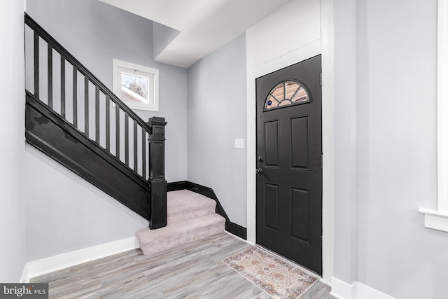 entryway featuring stairway, baseboards, and wood finished floors