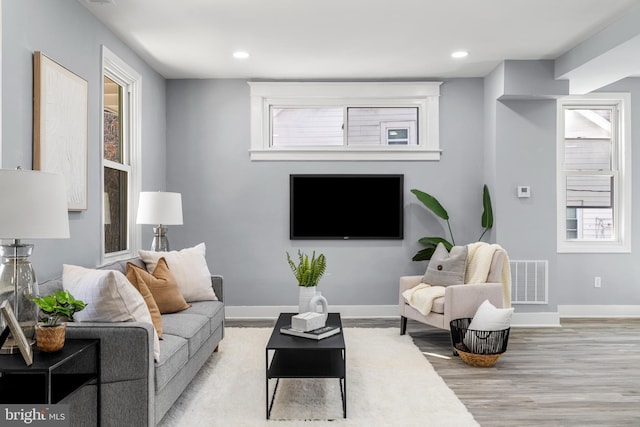 living room with recessed lighting, visible vents, baseboards, and light wood-style floors