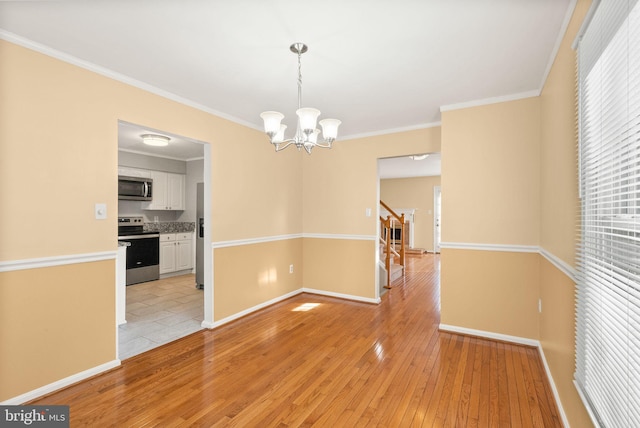 unfurnished dining area with a wealth of natural light, a notable chandelier, stairs, and light wood-type flooring