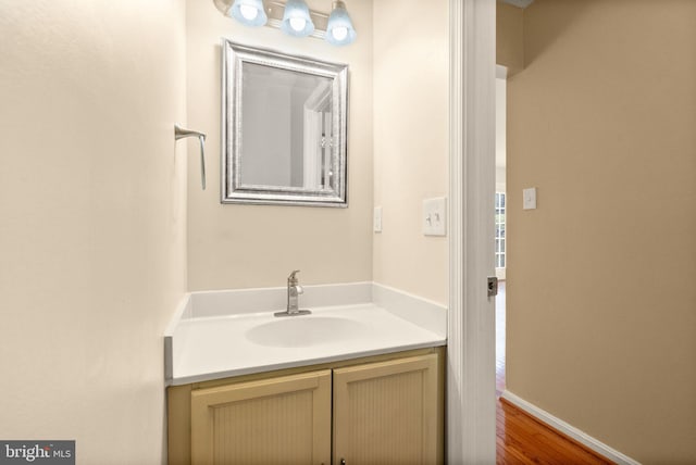 bathroom with vanity, baseboards, and wood finished floors