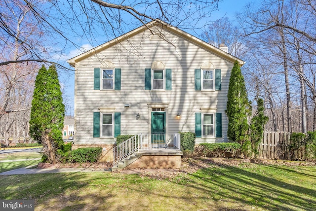 view of front of home featuring a front lawn, a chimney, and fence