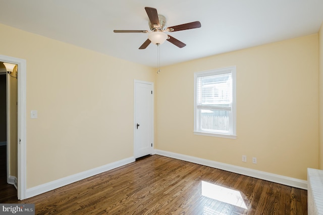 empty room with wood finished floors, baseboards, and ceiling fan