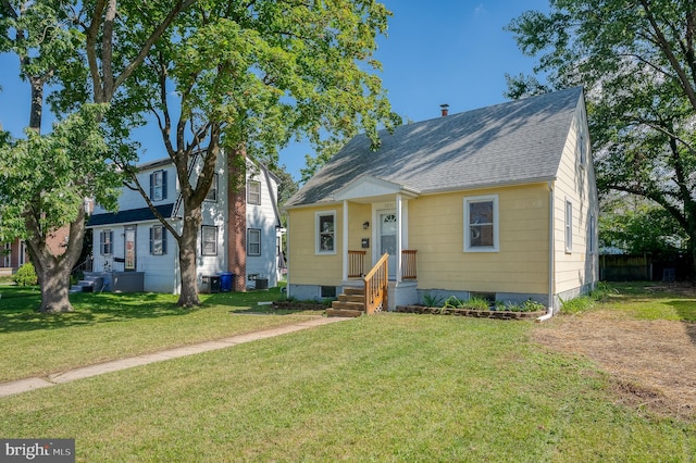 view of front of property featuring a front lawn and a shingled roof