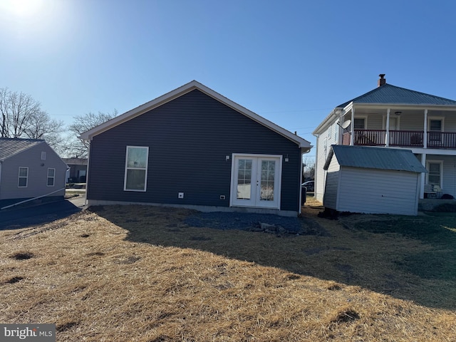 back of property with an outdoor structure and french doors