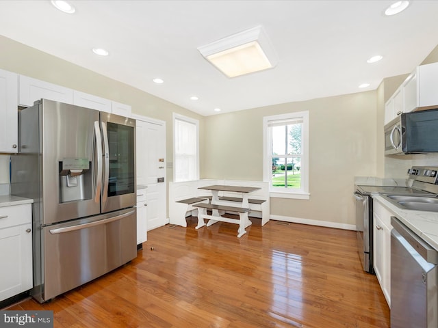 kitchen with white cabinets, recessed lighting, light wood-style floors, and stainless steel appliances