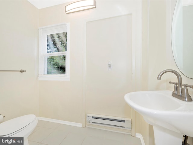 bathroom featuring a baseboard heating unit, baseboards, toilet, tile patterned floors, and a sink