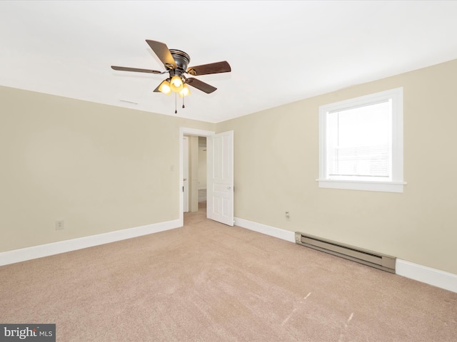 spare room with baseboard heating, light colored carpet, baseboards, and ceiling fan