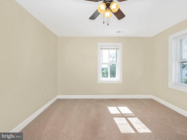 empty room featuring visible vents, carpet flooring, baseboards, and ceiling fan