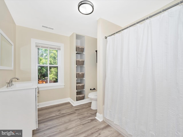 full bathroom featuring visible vents, baseboards, toilet, wood finished floors, and vanity