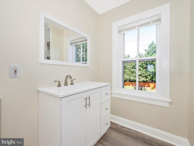 bathroom featuring vanity, baseboards, and wood finished floors