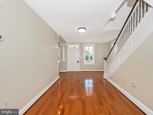 foyer with stairway, baseboards, and wood finished floors