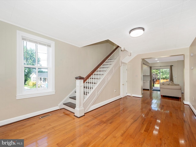 entryway with visible vents, stairs, baseboards, and wood-type flooring