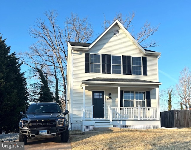 traditional-style house with a porch and fence