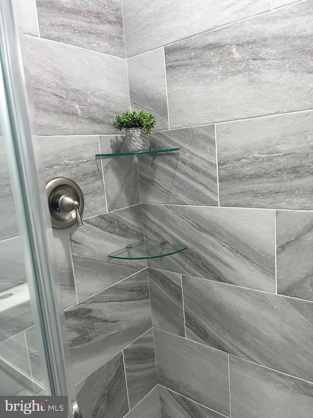 interior details featuring tiled shower