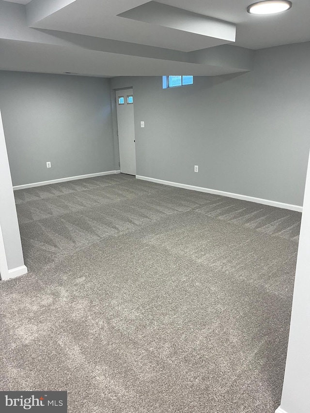 empty room featuring baseboards and carpet