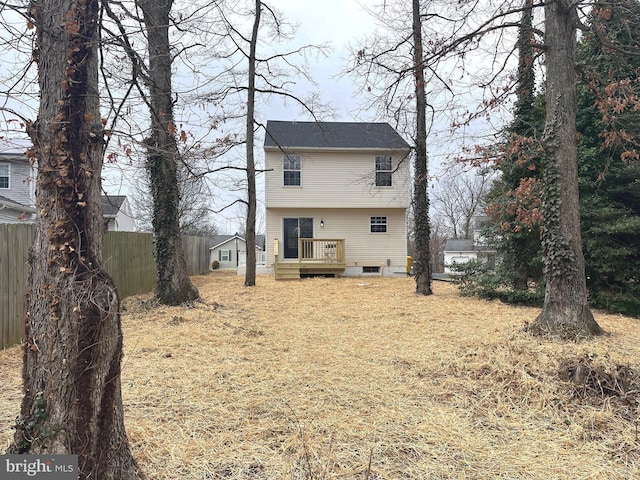 rear view of house featuring a wooden deck and fence