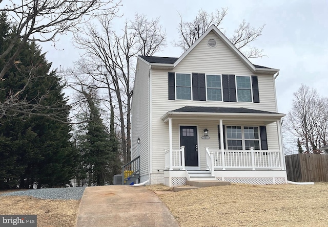 traditional-style house featuring a porch and fence