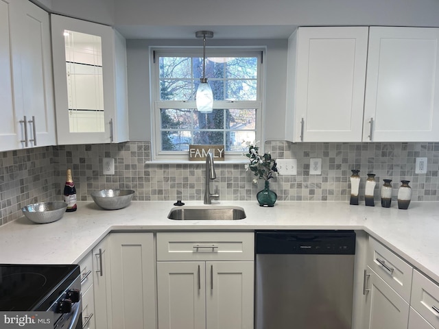 kitchen featuring stainless steel dishwasher, decorative backsplash, white cabinetry, and a sink