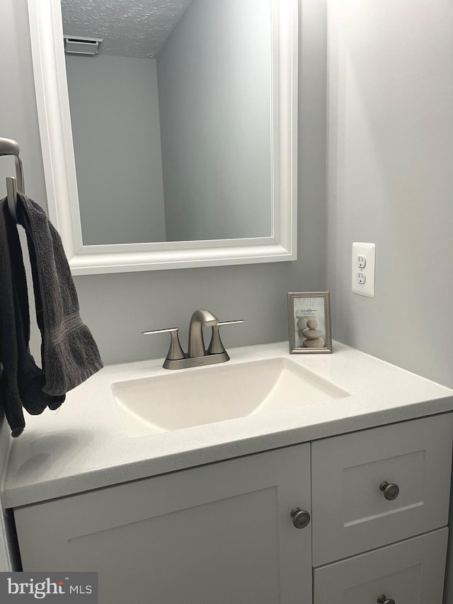 bathroom featuring a textured ceiling and vanity