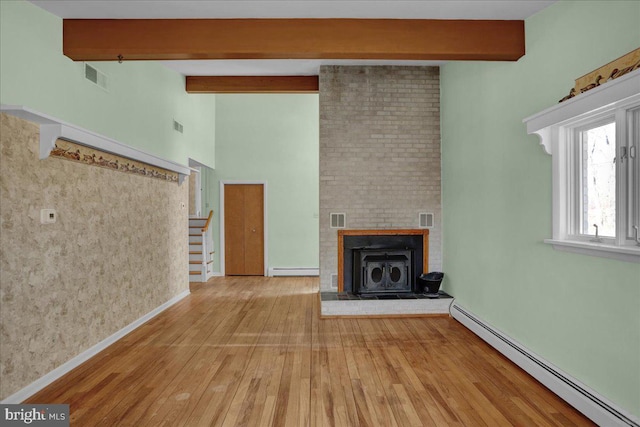 unfurnished living room featuring stairway, wood finished floors, visible vents, and a baseboard radiator