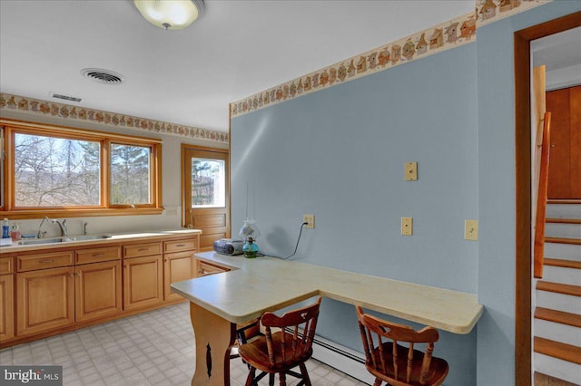 kitchen featuring light countertops, light floors, visible vents, and a sink