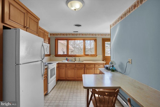 kitchen with light floors, white appliances, light countertops, and a sink