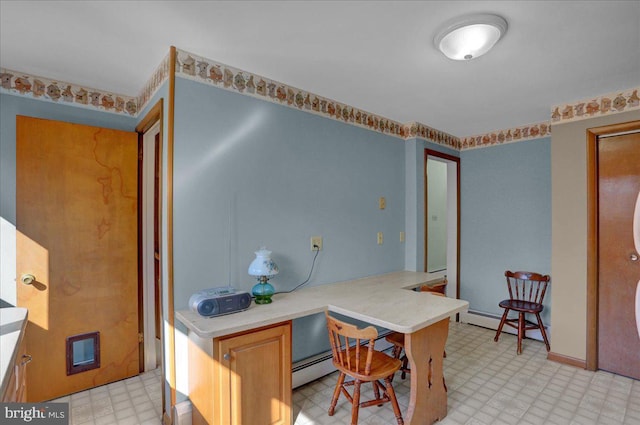 kitchen featuring light countertops, light floors, and a baseboard radiator