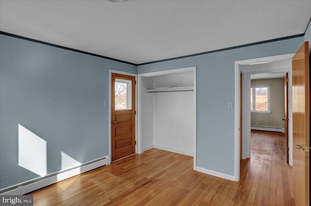 unfurnished bedroom with light wood-type flooring, a baseboard heating unit, and ornamental molding