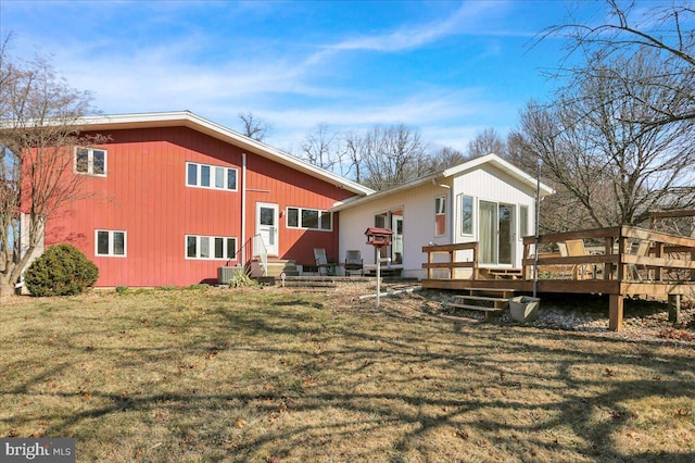 back of property with a yard and a wooden deck