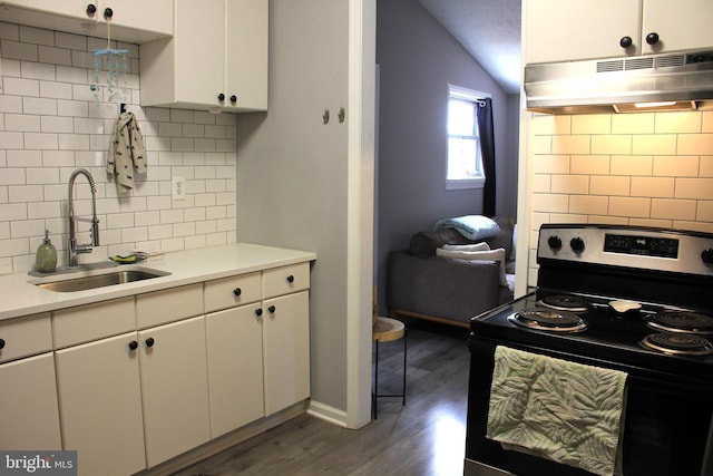 kitchen featuring a sink, electric range oven, light countertops, under cabinet range hood, and white cabinetry