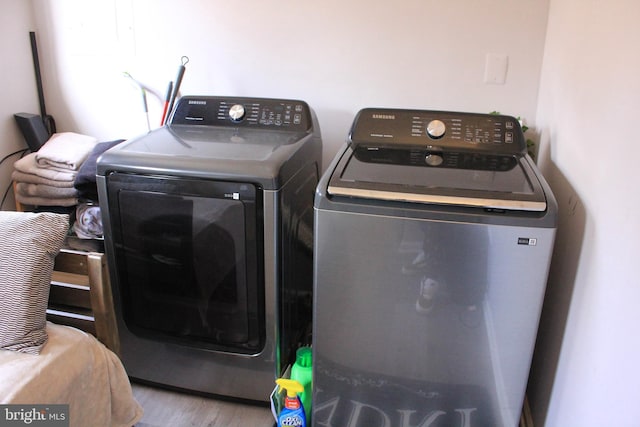 laundry room with independent washer and dryer, wood finished floors, and laundry area