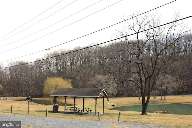 view of home's community featuring a gazebo, a lawn, a water view, and a wooded view