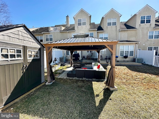 view of yard with a carport, fence, a gazebo, an outdoor structure, and a patio area